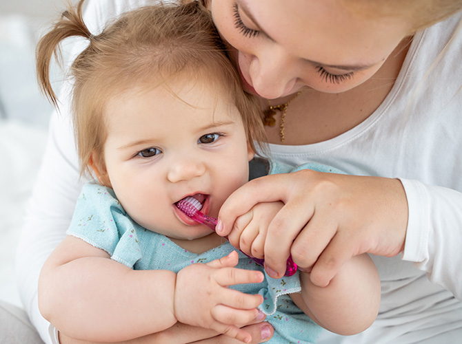 infant with toothbrush