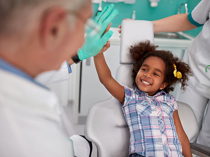 young girl giving her dentist a high-five